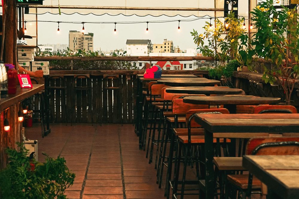 Chenh Venh’s space exudes a perfect vintage boho vibe, with a harmonious blend of rustic wood and greenery (Source: Chênh Vênh Rooftop)